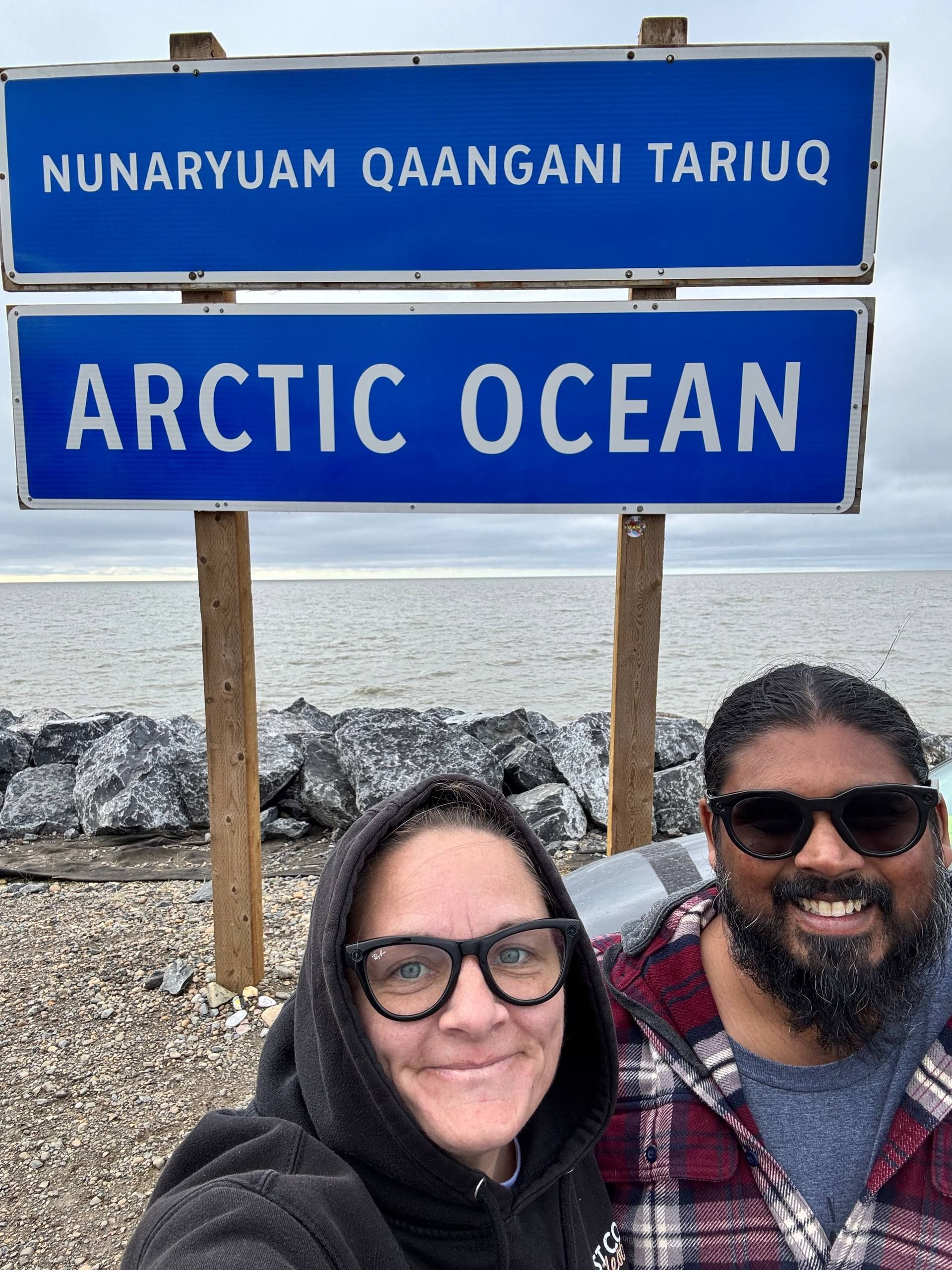 Chey and Mark at the Arctic Ocean sign in Tuktoyaktuk